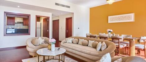 Una sala de estar moderna con un conjunto de sofás, una mesa de centro y un comedor con sillas y una mesa.