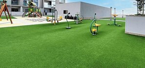 Une aire de jeux équipée d’appareils de musculation et d’un toboggan.