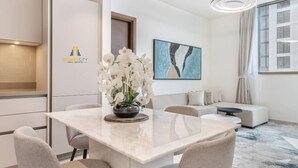 A modern interior with a dining area, a sofa, and a painting on the wall. - Peaceful Location | All Bills Included (Dubai)