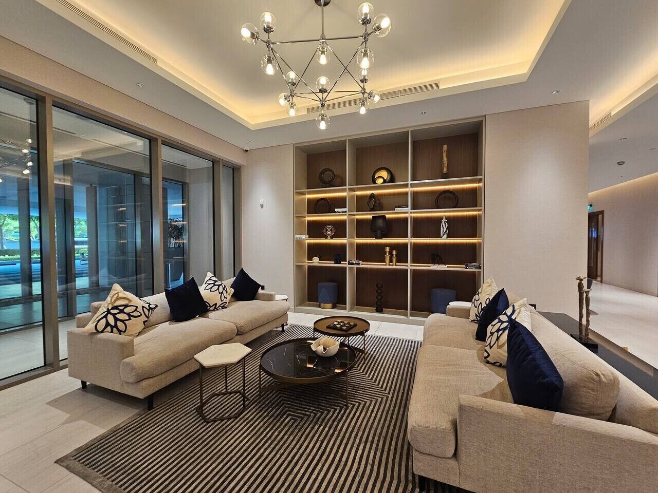 Ein modernes Wohnzimmer mit einer Sofagarnitur, einem Couchtisch und einer eingebauten Regaleinheit mit dekorativen Accessoires.