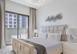 Ein Hotelzimmer mit einem großen Bett, Blick auf die Stadt und einer dekorativen Wandgestalt.