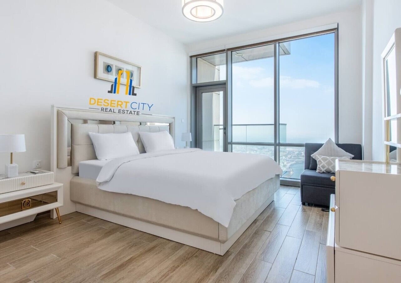 Une chambre d’hôtel moderne avec un grand lit, une table de chevet, un bureau et une vue sur la ville.