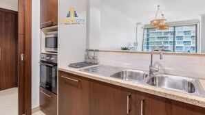 Una cocina moderna con electrodomésticos de acero inoxidable, armarios de madera y un amplio ventanal con vistas a la ciudad.