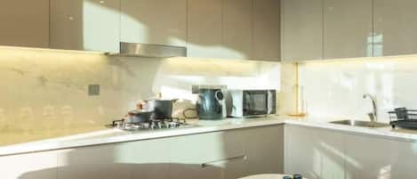 A modern kitchen with a marble backsplash, stainless steel appliances, and a minimalist design.