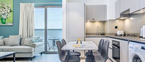 Un apartamento moderno con comedor, cocina y vistas al mar.