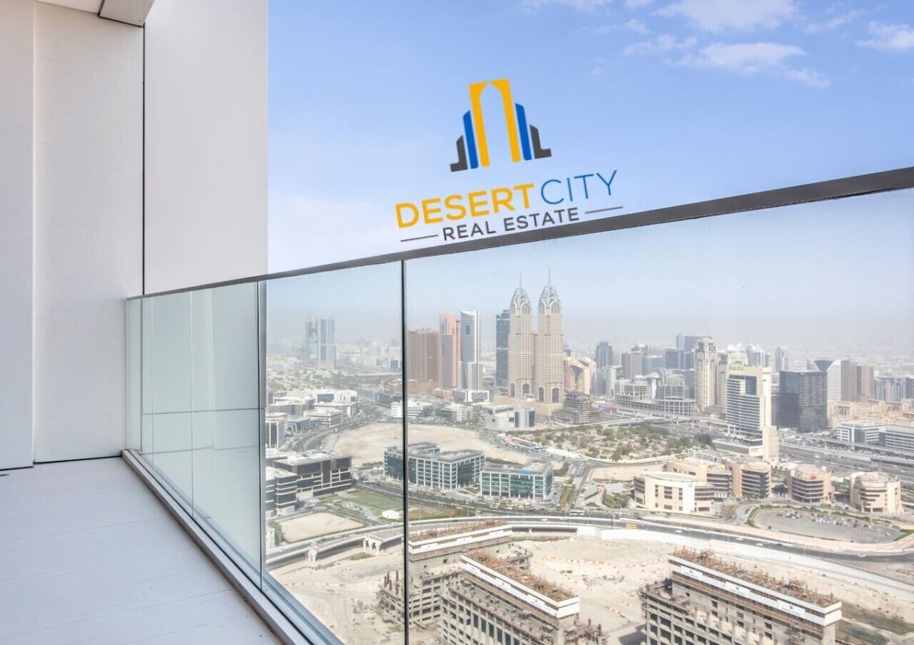 Uitzicht vanaf een balkon met glazen hekwerk op een stadsgezicht, met het logo van Desert City Real Estate.