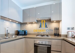 Une cuisine moderne équipée d’un four à micro-ondes encastré, d’une cuisinière à gaz et d’un four.
