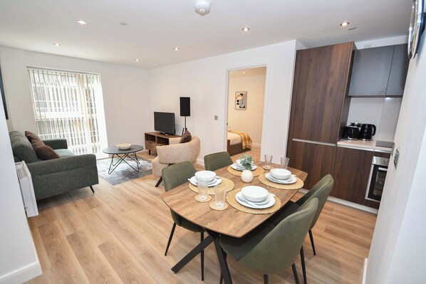 A modern living space with a dining area, kitchen, and a bedroom. - Bright 2 Bed Apartment in Central Leeds - Sleeps 4 (Leeds)
