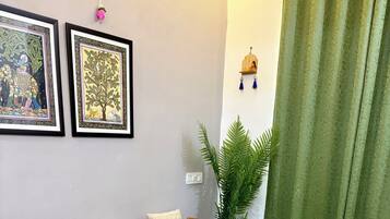 A living room with a sofa, wooden coffee table, and a plant.