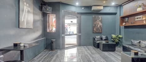 A modern interior with a marble floor, a seating area with sofas and a coffee table, and artwork on the walls.