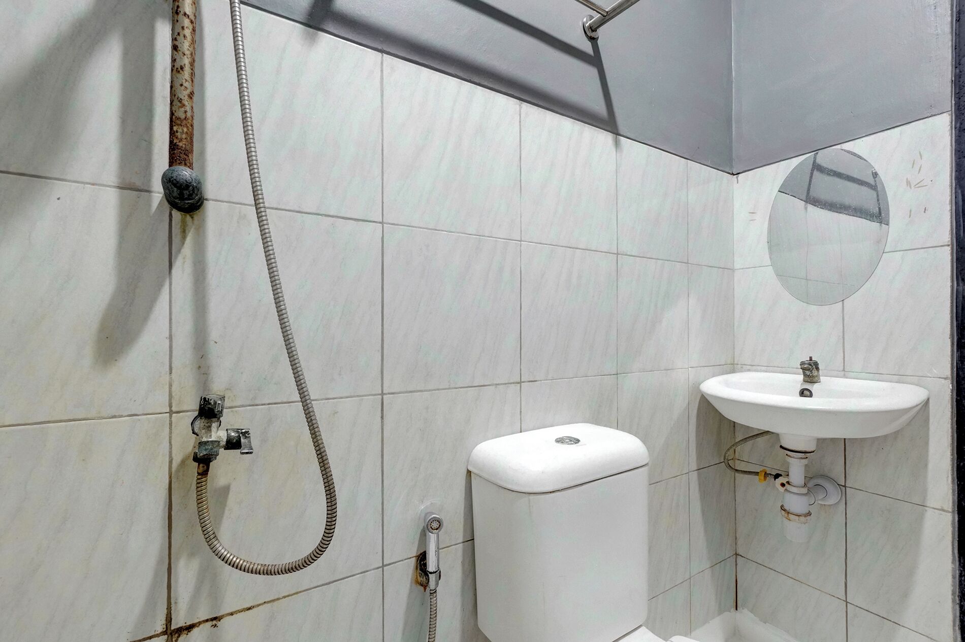 A bathroom with a shower, toilet, sink, and a mirror.
