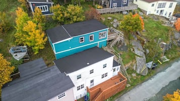 A residential area with multiple houses, including a two-story house with a blue roof and a white house with a red door.