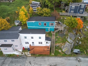Un barrio residencial con casas, una escalera de madera y un pequeño muelle.