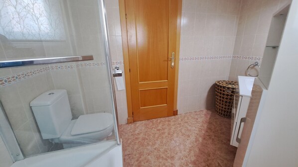 A bathroom with a toilet, a shower, and a wooden door. - Ref: 287. Fantastic 3 bedroom apartment near the sea (Fuengirola)