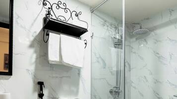 Un baño moderno con inodoro, ducha y pared de mármol.