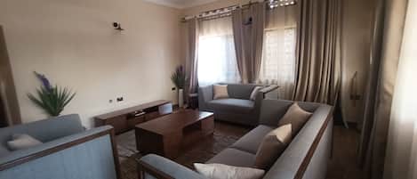 A living room with a sectional sofa, a coffee table, and a TV stand.