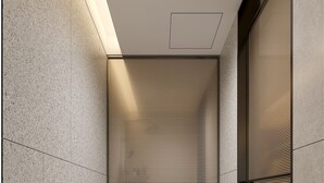 Un baño moderno con un inodoro blanco, una pared con textura y una puerta corredera.