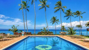 A swimming pool with a tropical view, surrounded by palm trees and lounge chairs. - Mahina Surf 1-Bedroom Ocean View Villa + Free Rental Car w/ 6+ Nights | MSF-122 by KBM (Lahaina)