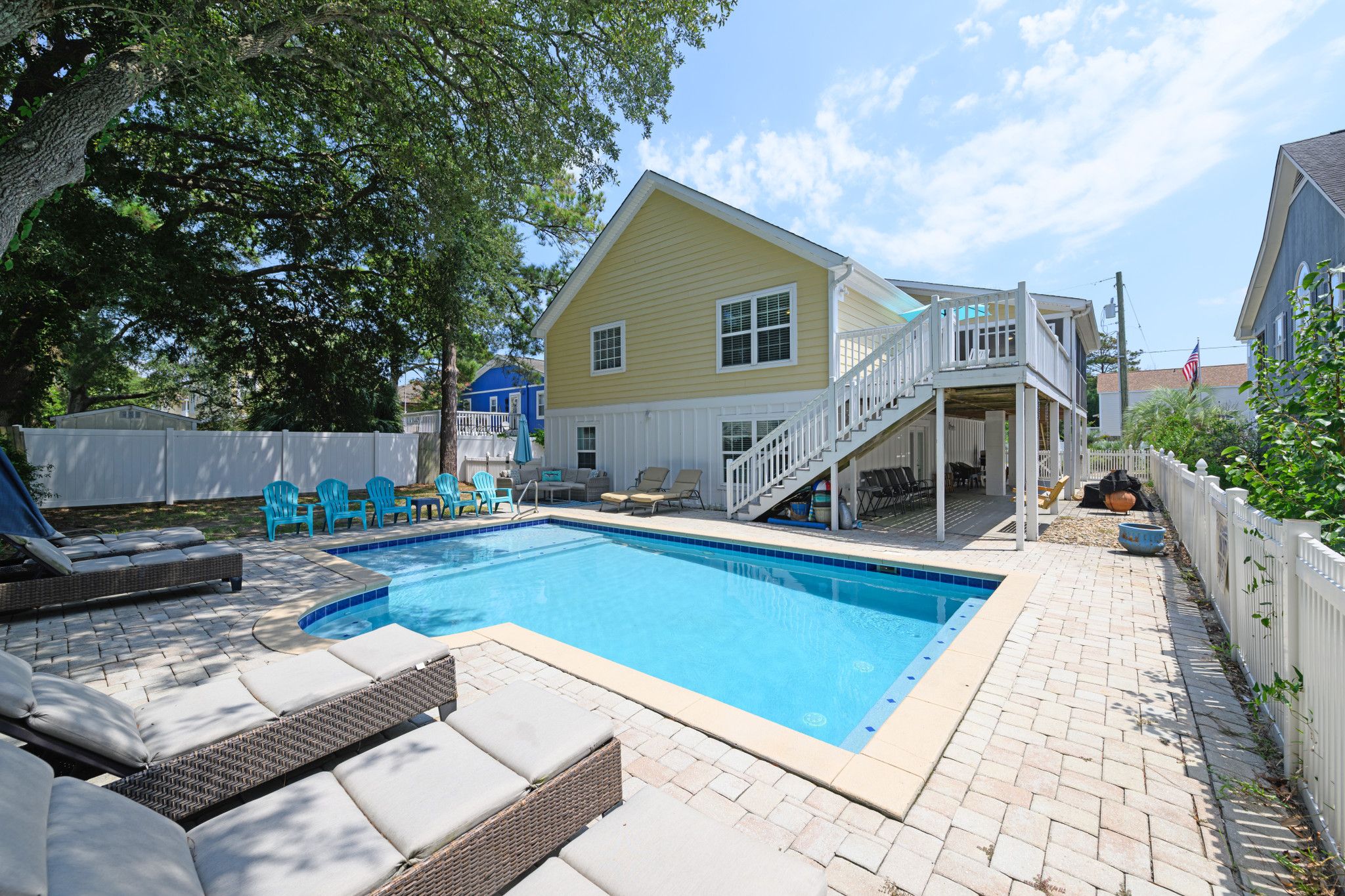Un jardin avec une piscine, du mobilier d’extérieur et un patio couvert.