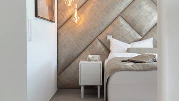 Ein Schlafzimmer mit einem großen Bett, einem Nachttisch, einer Wandleuchte und einem gerahmten Bild.