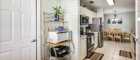 A compact kitchen with a microwave, oven, and refrigerator.
