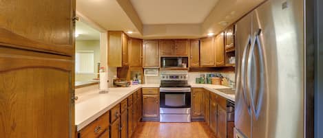 A kitchen with wooden cabinets, stainless steel appliances, and a central island.