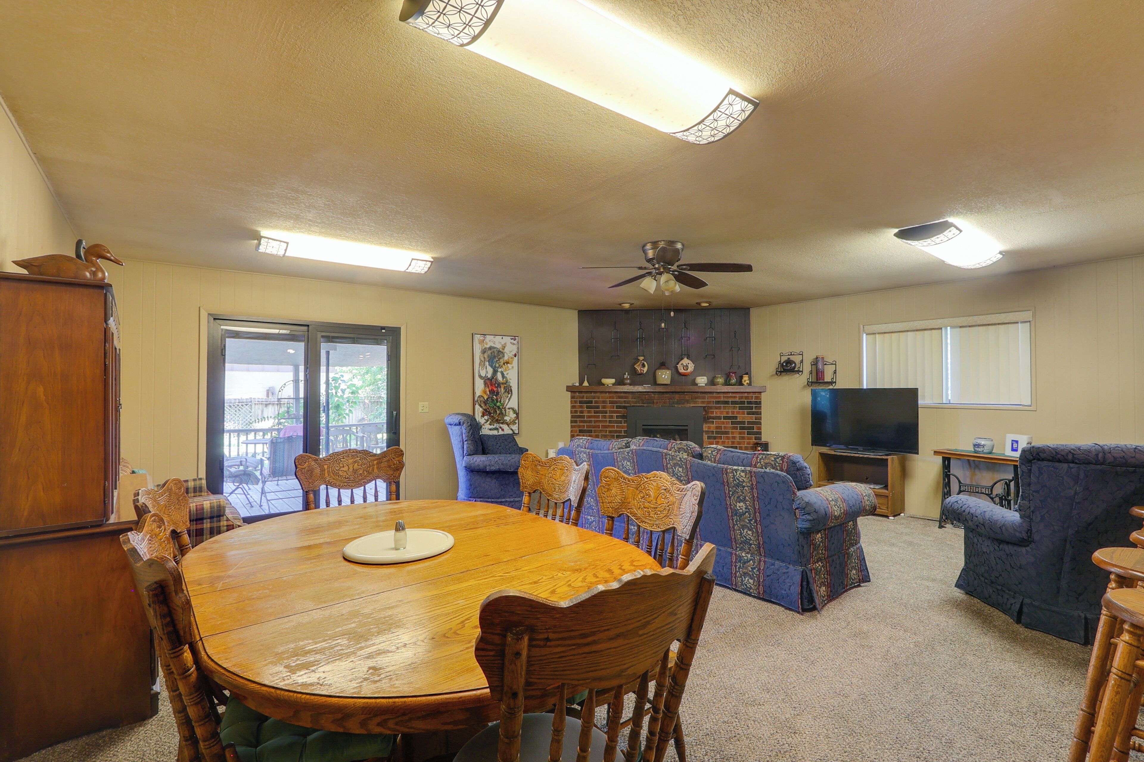 A spacious living room with a dining area, a fireplace, and a television.