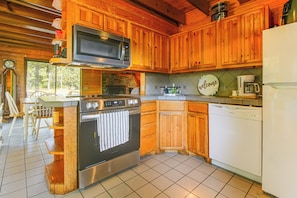 A kitchen with wooden cabinets, a stainless steel oven, a microwave, a coffee maker, and a dishwasher.