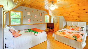A room with two beds, a television, and a wooden ceiling.