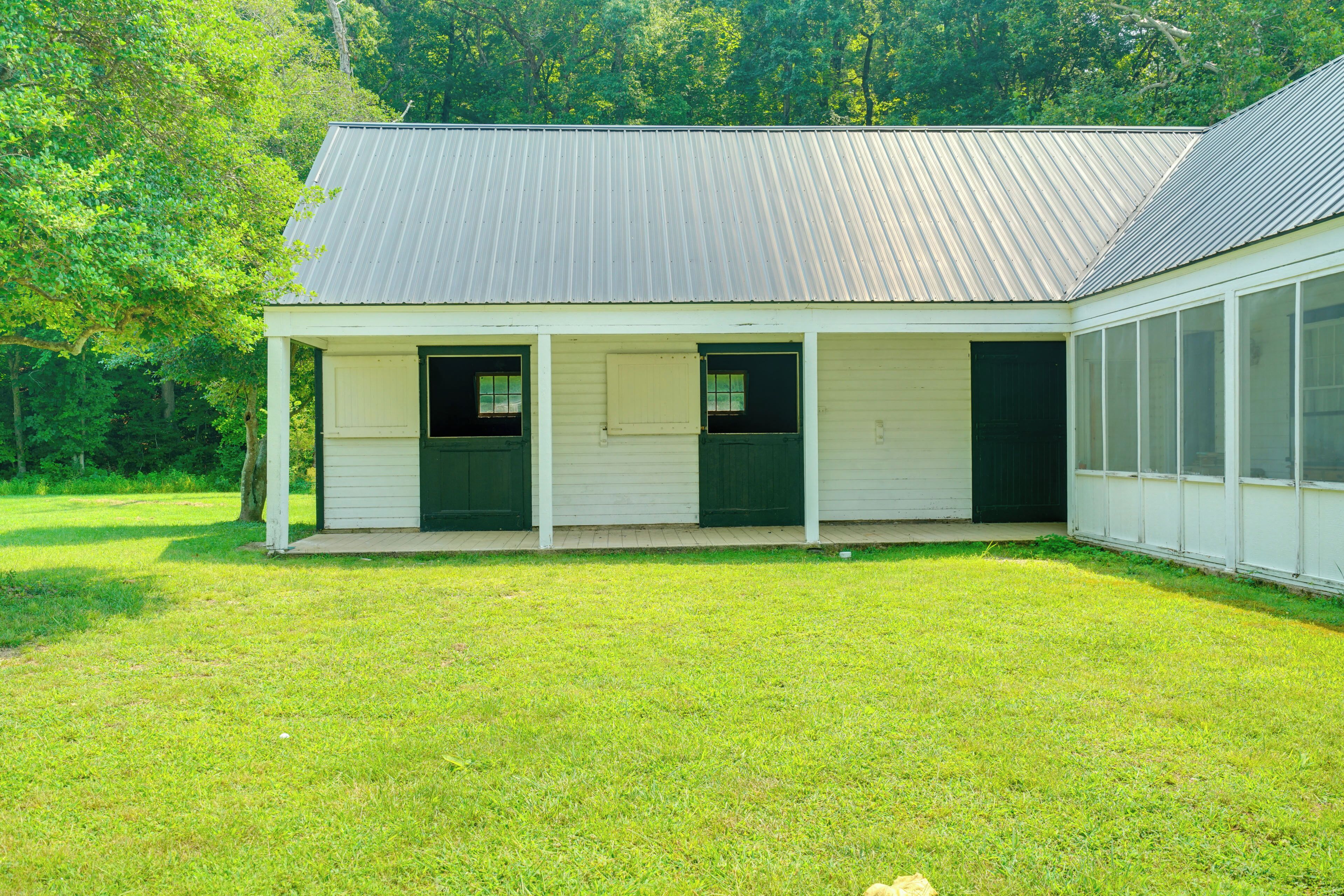 A single-story building with a porch, a covered entryway, and a large window on the right side.