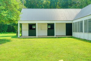 A single-story building with a porch, a covered entryway, and a large window on the right side.