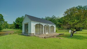 A small, single-story structure with a pitched roof, large windows, and a stone foundation.