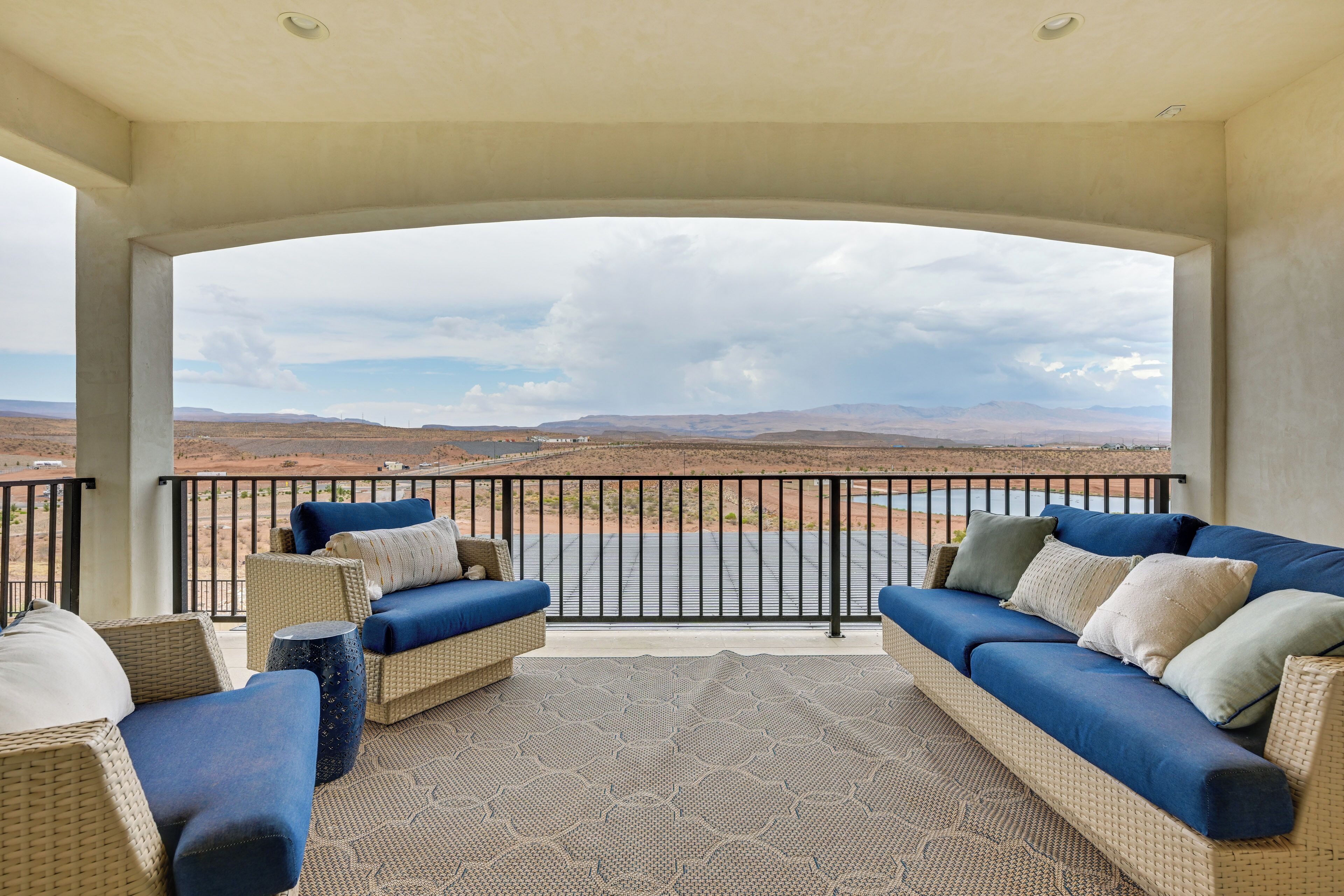 A covered outdoor seating area with a view of a desert landscape.