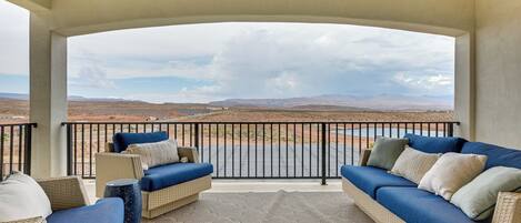 A covered outdoor seating area with a view of a desert landscape.