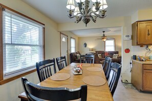 A dining area with a wooden table, black chairs, and a chandelier.