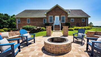 A brick house with a fire pit and outdoor seating.