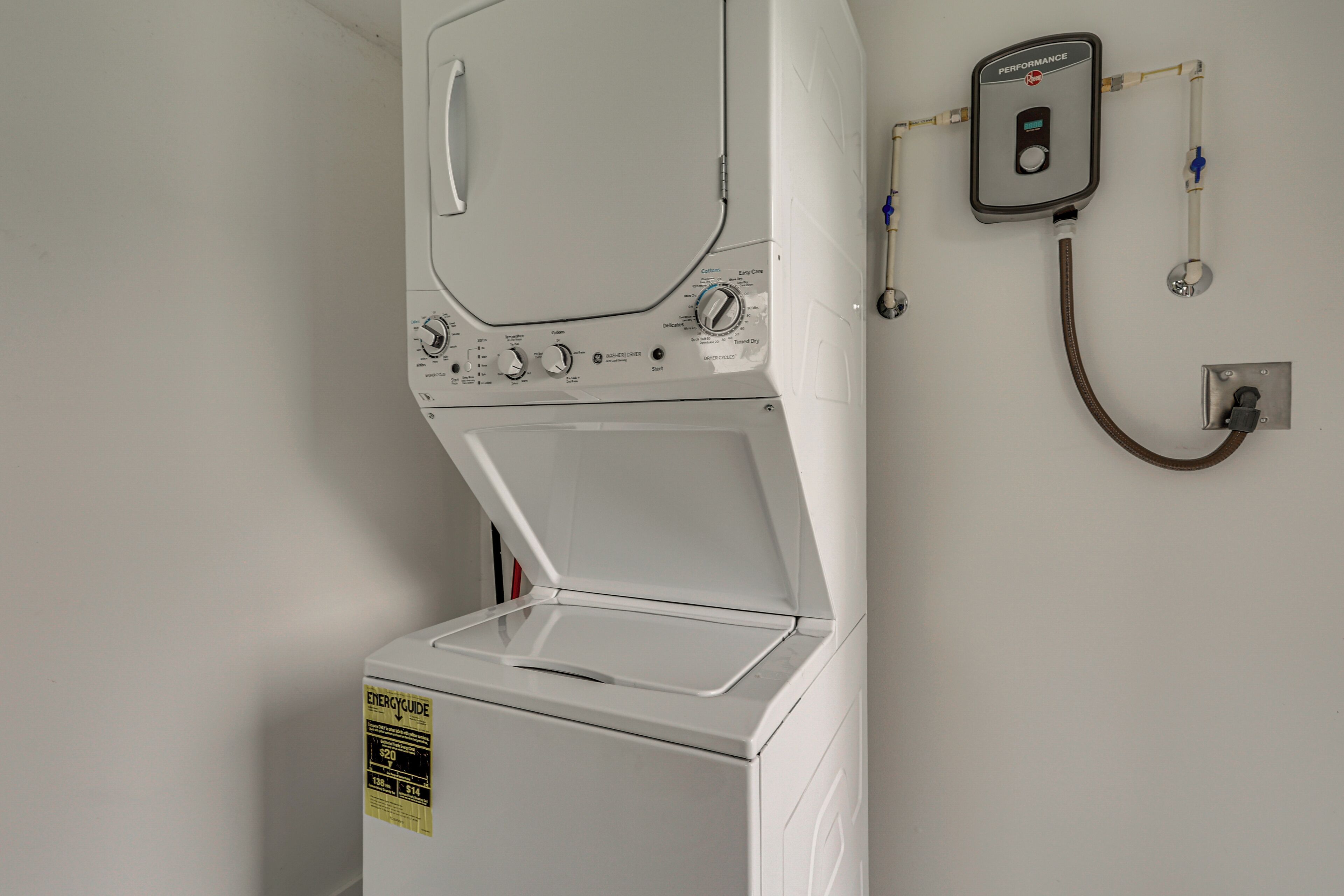 A white wall-mounted washer and dryer unit with a control panel and a performance meter.