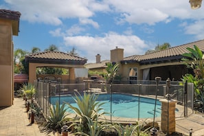 A swimming pool surrounded by a fence, with a patio area and a covered seating area. - Bakersfield Guest Suite, 11 Mi to Dtwn! (Bakersfield)
