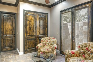A room with a wooden door, a glass coffee table, and a floral sofa. - Bakersfield Guest Suite, 11 Mi to Dtwn! (Bakersfield)