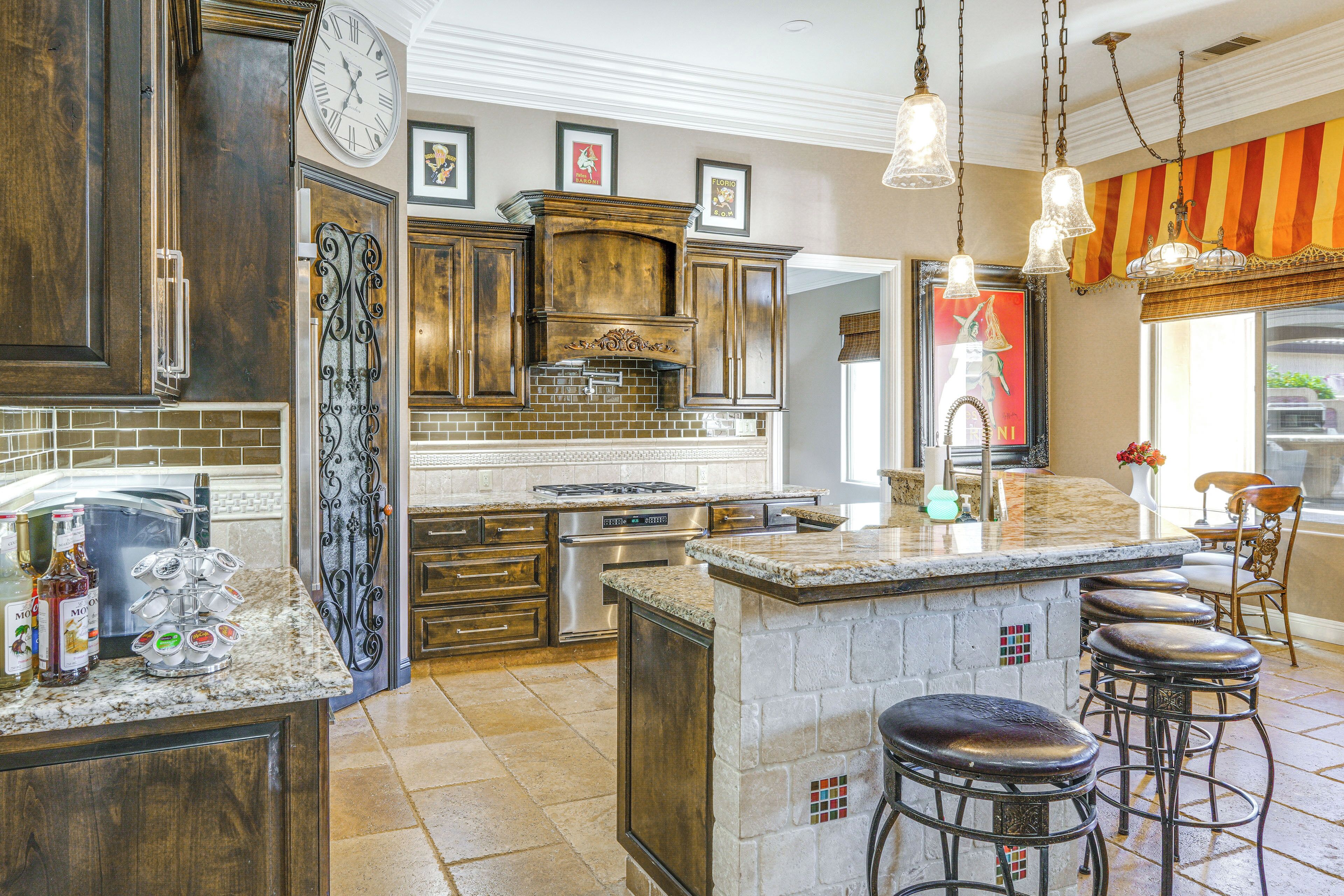 A spacious kitchen with a large island, stainless steel appliances, and a decorative backsplash.