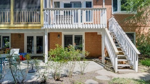 A two-story building with a balcony, a staircase, and a patio area with outdoor furniture. - Gateway to DC, Waterfalls & More! Mclean Apartment (McLean)