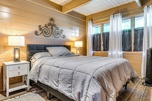 A bedroom with a bed, two bedside tables with lamps, a decorative wall piece, and a window with curtains. - Walk to Dtwn Rockville! Prairie-inspired Retreat (Rockville)