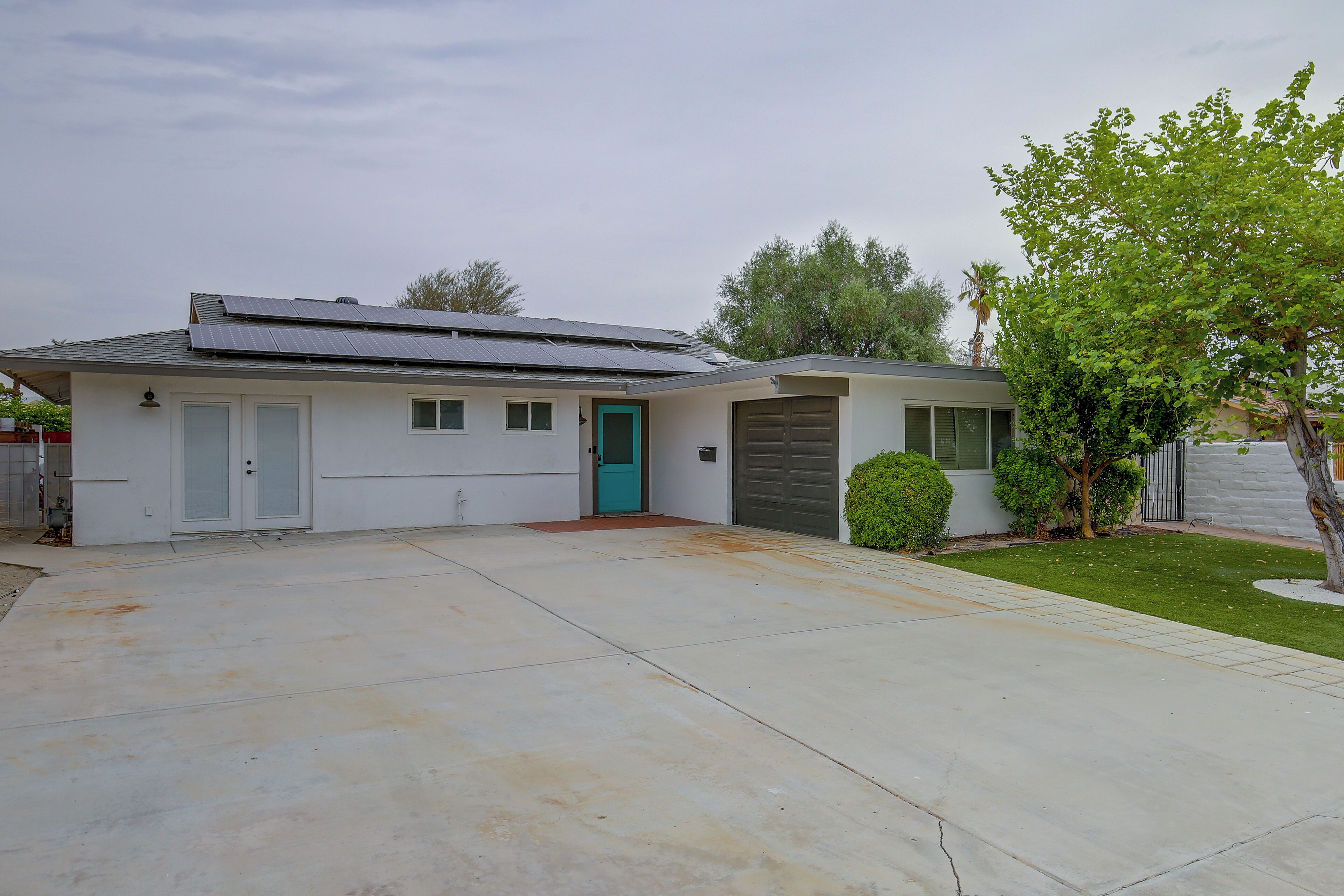 A single-story house with a garage, a front door, and a small driveway.