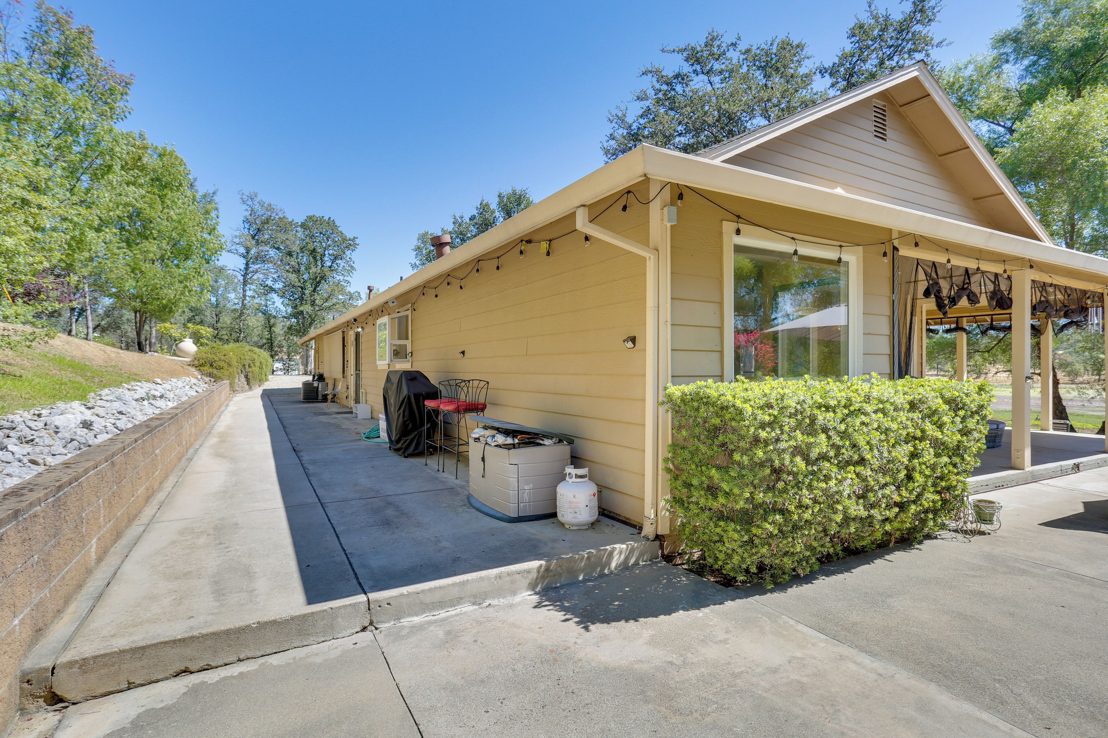 A single-story building with a covered patio area, a barbecue grill, and a gas cylinder outside.