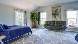 A spacious bedroom with a large bed, a leather sofa, and a potted plant. - Bay Views + Stargazing! Spacious Mount Vernon Home (Mount Vernon)