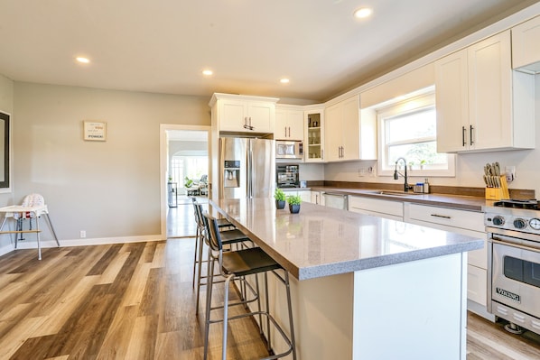A modern kitchen with a central island, stainless steel appliances, and a view to the dining area. - Bay Views + Stargazing! Spacious Mount Vernon Home (Mount Vernon)