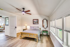 A bedroom with a wooden bed, a ceiling fan, a painting, a mirror, and a window with blinds. - Great for Families! Dothan Getaway w/ Large Yard (Dothan)