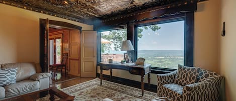Un salon avec vue, un plafond décoré et une table basse en bois.