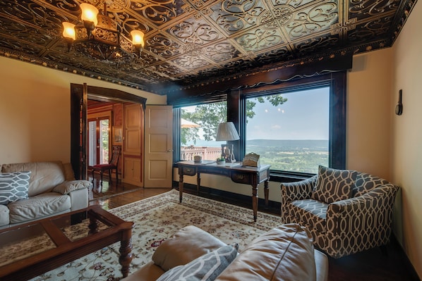 A living room with a view, ornate ceiling, and a wooden coffee table. - Luxury Tudor Estate Pool, Spa and Valley Views (Sugarloaf)