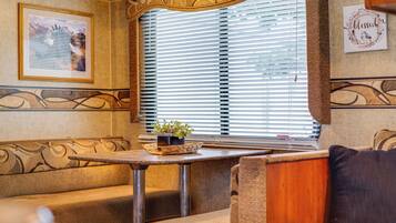 A cozy interior with a sofa, a small table with a plant, and a window with blinds.